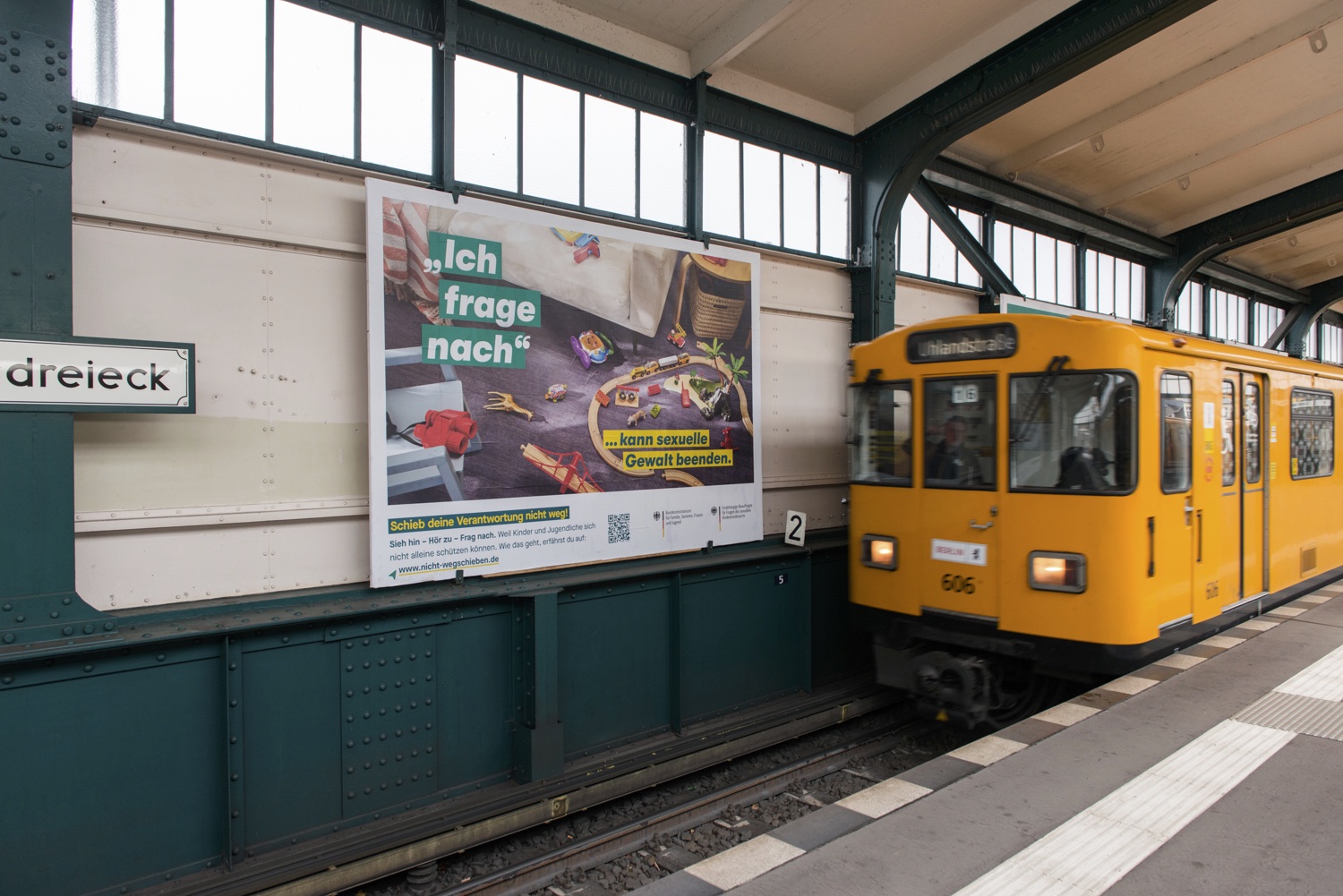 Bahnhaltestelle, zu sehen ist eine U-Bahn und ein Kampagnenmotiv